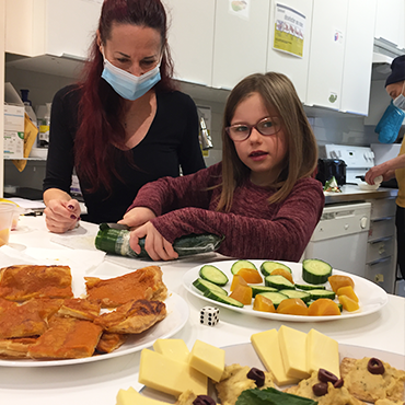 Éducatrice spécialisée de Répit Providence Maison Hochelaga Maisonneuve en train de montrer à une enfant comment préparer le dîner.
